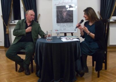 Janusz L. Wisniewski i prowadząca spotkanie rozmawiają siedząc przy okrągłym stoliku